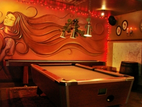 Pool table with mural behind.