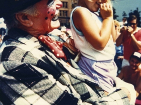 Ernest Borgnine as a clown with a child at the Circus Parade, late 1990s