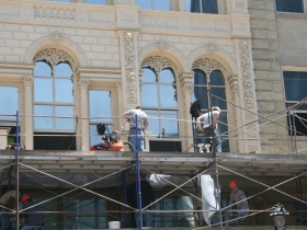 Construction workers putting finishing touches on the Iron Block Building.