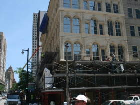 Construction workers putting finishing touches on the Iron Block Building.