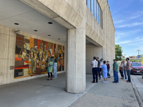 Ann Dufkis discusses her father’s mural with Lillian Sizemore at 803 W. Michigan St.