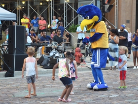 Children dance with the Secure Parking Mascot at the Night Market
