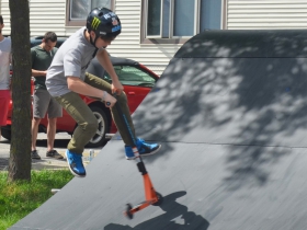 Kid does a stunt on a scooter at the Division BMX Stage