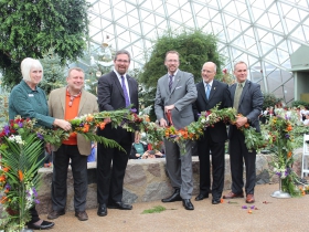 Officials cut a floral ribbon at the Domes Grand Reopening, December 1, 2016 L-R, Domes Director Sandy Folaron, State Rep. Josh Zepnick, Sup. Jason Haas, Sup. Theo Lipscomb, Northwestern Mutual President Eric Christopherson, Milwaukee County Parks Director John Dargle.