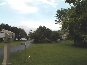 A mailbox greets visitors to the Town of Grafton lakeside home of Gary R. George while a peek of Lake Michigan is visible in the distance to the left of the dwelling. 