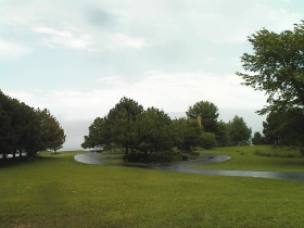 ​Originally the planting of the center island was designed to highlight, not obscure the residence. To the right of the island can be seen the septic system which stores the George family's wastes until it can be hauled away. This area is not served by the MMSD. Lack of sewerage service greatly limits the density of population here, hence 3-acre lakefront lots.