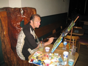 ​Timothy Klosss paints during a Poet's Monday reading. The painting was later given to featured poet, Tom Jones. 