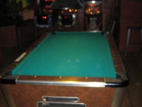 The pool table is in the old barber shop portion of the building. Sometimes it is rolled out onto the street.