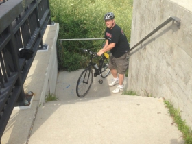 Dave Reid climbing the stairs with his bike.