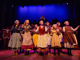 (I. to r. front line) Erin Fricker (Tzeitel), Kynkade McLachlan (Hodel), Naomi Kriege (Chava), Alice Nguyen (Bielke), Allyson Lindberg (Shprintze), ensemble, (I. to r. background) Andrew Varela (Tevye), and Kimberly Hanson (The Fiddler), in Skylight Music Theatre’s production of Fiddler on the Roof running October 3-26, 2025.