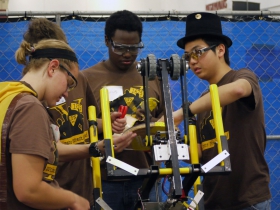 Students from FIRST Robotics Team 1675, Ultimate Protection Squad from Milwaukee, tinkering with their robot