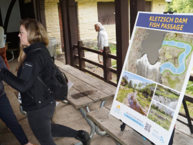 Stacy Hron, Wisconsin Department of Natural Resources project manager, discusses the Kletzsch fishway project with a member of the public at a June 2023 meeting in Kletzsch Park. The public preferred the current east bank alternative to an earlier west bank proposal.