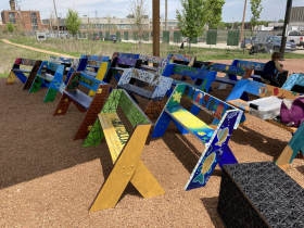 ArtWorks for Milwaukee painted Aldo Leopold benches at Green Tech Station combined with those painted from previous years. A modular stormwater block is lower right