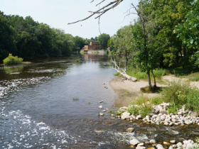 A bobber and tangled fishing line hang from a dead branch just downstream of the Mequon-Thiensville dam and fishway in August 2023
