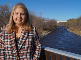 Cheryl Nenn with Milwaukee Riverkeeper stands on the pedestrian bridge over the former North Avenue Dam in November 2022