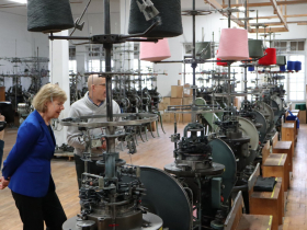 Sen. Tammy Baldwin inspects textile equipment at Wisconsin Knitwear