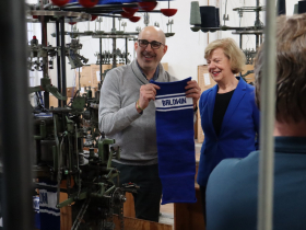 Steven Arenzon holds a custom knit hat for Sen. Tammy Baldwin