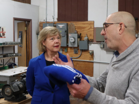 Sen. Tammy Baldwin speaks to Steven Arenzon, president of Wisconsin Knitwear