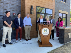 Brian Spoerl speaks at The Hampton, surrounded by his development team and state and county officials. 