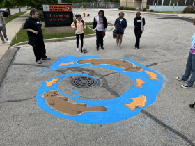 ArtWorks for Milwaukee interns consider their storm drain mural featuring cartoon otters and fish