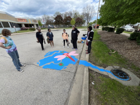 ArtWorks for Milwaukee interns consider the storm drain mural featuring a dragonfly