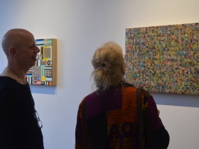 People look at works by Mark Ottens at Portrait Society Gallery