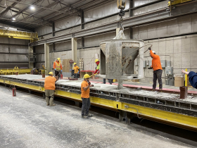 Stonecast workers pouring and smoothing a panel
