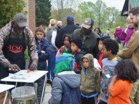 Kids surround a fish cleaning and filleting demonstration