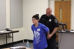 A STOP participant gets cuffed -- just for fun. Photo by Mark Doremus.