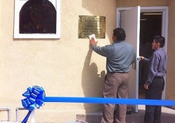 A volunteer shines the La Luz del Mundo Family Services sign outside at the center before the event.