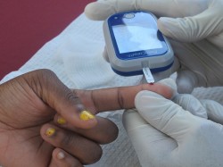 A young woman gets a free blood sugar screening. (Photo by Shakara Robinson)