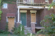 Boarded-up houses drag down property values in Milwaukee neighborhoods. (Photo by Scottie Lee Meyers)