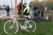 Friends and family members of Tom Van Hoof dig a hole for the concrete foundation where they installed the Ghost Bike at the intersection of the Oak Leaf Trail and Mill Road in Glendale.