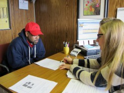 Supervisor Angela Catania explains how to regain a driver’s license to Hakim Fudge, who has 15 unpaid tickets, at the Center for Driver’s License Recovery and Employability. (Photo by Rick Brown)