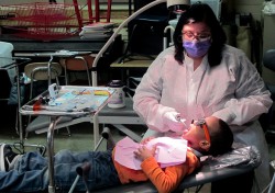 Dental hygienist Geri Travia cleans Corey Wilson's teeth. (Photo by Andrea Waxman)