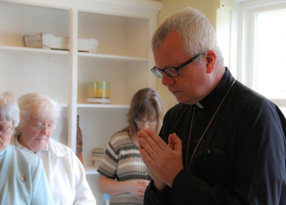 Auxiliary Bishop for the Archdiocese of Milwaukee Donald J. Hying leads friends and supporters of the Clare Community project in prayer at a celebration of the new women's shelter. (Photo by Karen Slattery)