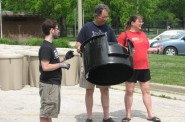 Volunteer Phil Busch assists two customers who purchased a compost bin.