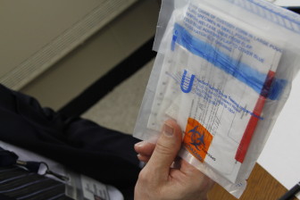 Chain of custody: Clippings go into a bag labeled “biohazard,” even though they aren’t really biohazards, under the eye of an assessor. The bags are mailed to U.S. Drug Testing Laboratories in Des Plaines, Ill. Photo by Kate Golden / Wisconsin Center for Investigative Journalism.