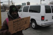 An unidentified homeless man holds a sign asking for money at 25th Street and West St. Paul Avenue. (Photo by Brendan O’Brien)