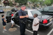 A Milwaukee police officer talks with a boy in Clarke Square. (Photo by Edgar Mendez)