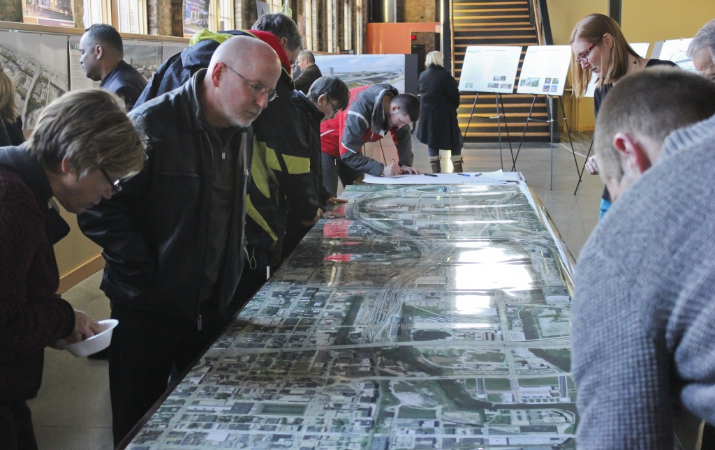 Visitors pore over an aerial map at an open house to preview development of the Menomonee Valley, held at the Zimmerman Architectural Studios. (Photo by Alhaji Camara)