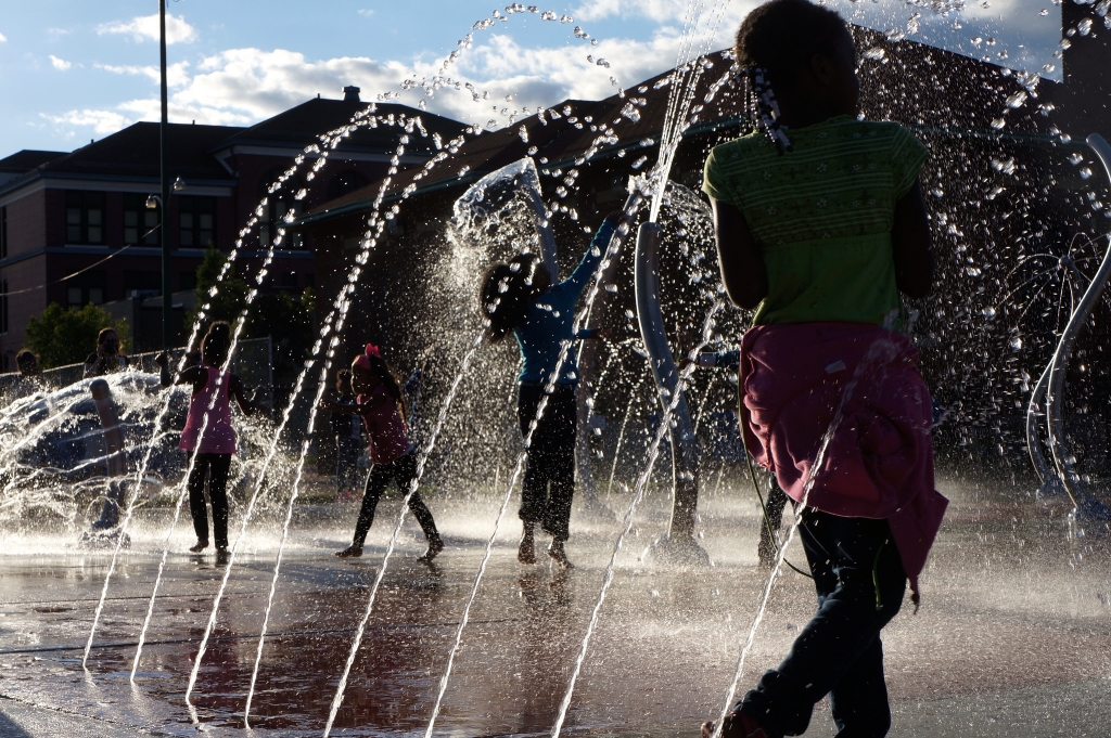 With official business done, the splash pad was turned on, much to the delight of neighborhood youth. Photo by Adam Carr.