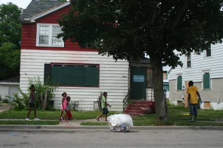Children walk down the one-way Port Sunlight Way in Garden Homes while ambassadors pick up garbage. Photo by Jabril Faraj.