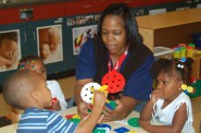 Nikole Foster, an early childhood education teacher, helps students with an art project at the Northside YMCA location. Photo by Stephanie Harte.