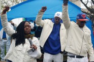 (From left) Markasa Chambers, a member of the Coalition for Justice, and brothers Nate Hamilton and Dameion Perkins lead supporters in 14 seconds of silence, symbolizing the 14 bullets that felled Dontre Hamilton two years ago. Photo by Andrea Waxman.