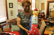 Artist Della Wells displays one of her handmade dolls in her home. Photo by Emmy A. Yates.