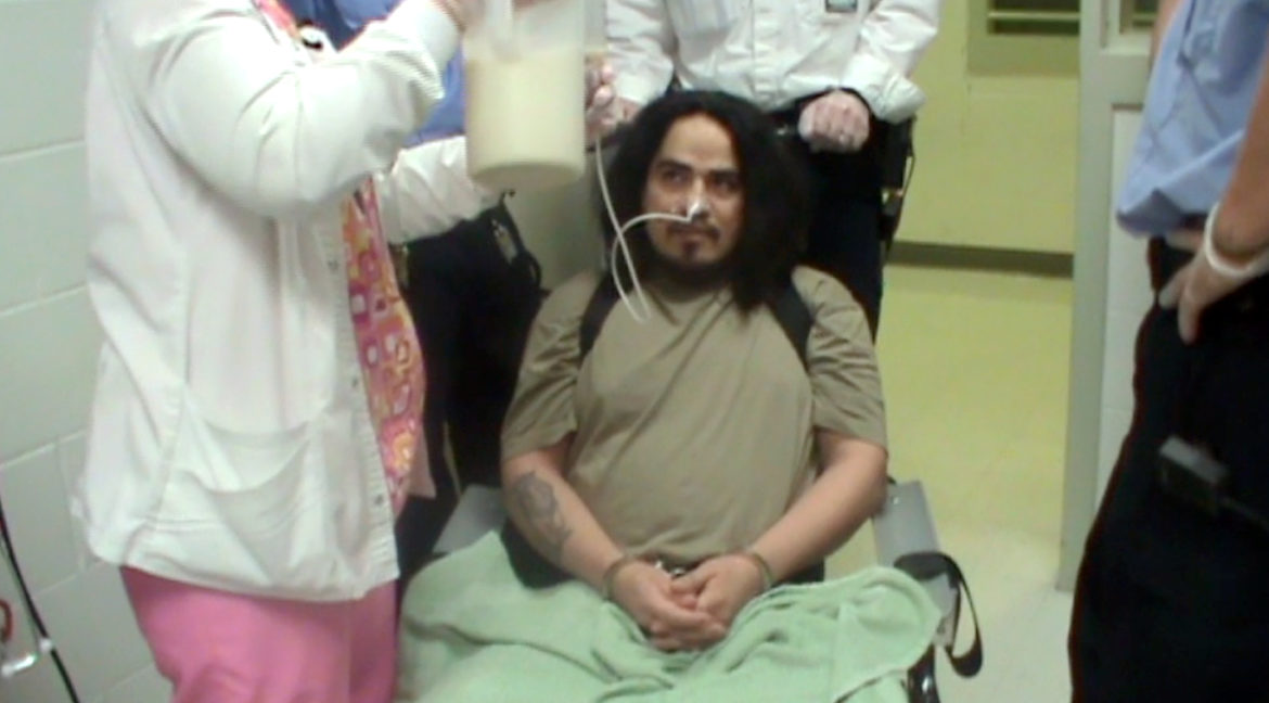 Waupun Correctional Institution inmate Cesar DeLeon is shown being force fed June 20 in this screen grab from a video Thursday in Dodge County Circuit Court. DeLeon, who along with several other Wisconsin inmates is hunger striking to protest long-term solitary confinement, was unable to convince a judge to withdraw the force-feeding order. Photo courtesy of the Wisconsin Department of Corrections.