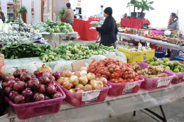 Customers shop for fruits and vegetables at the Milwaukee Asian Public Market Phongsavan. Photo by Dean Bibens.