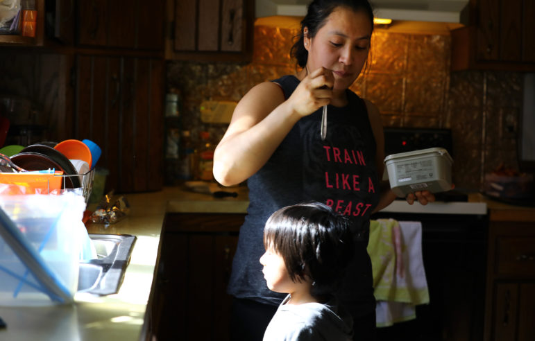 "Rosa" makes food for her 3-year-old son at their home on a dairy farm in Pepin County, Wis. She says she has noticed a change in the way her family is treated in the community since Donald Trump's election. Photo by Coburn Dukehart of the Wisconsin Center for Investigative Journalism.