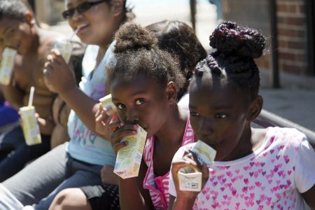 Children drink juice boxes during a snack break. Photo courtesy of Hunger Task Force.